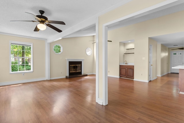 4162 Murrells Inlet Rd, Murrells Inlet, SC 29576 - unfurnished living room featuring dark wood-style floors, ceiling fan, a glass covered fireplace, and baseboards