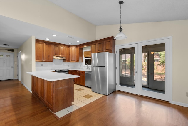 4162 Murrells Inlet Rd, Murrells Inlet, SC 29576 - kitchen with appliances with stainless steel finishes, a peninsula, light wood-style floors, brown cabinetry, and recessed lighting
