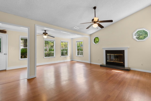 4162 Murrells Inlet Rd, Murrells Inlet, SC 29576 - unfurnished living room featuring ceiling fan, wood finished floors, a glass covered fireplace, lofted ceiling, and baseboards