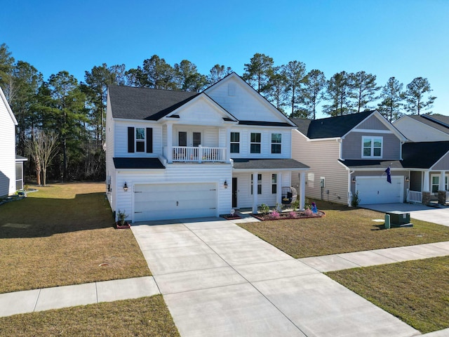 view of front of house featuring a garage, a front yard, a balcony, and driveway