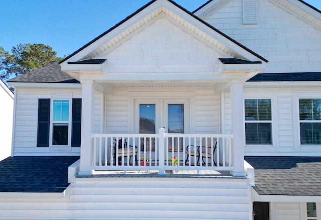 exterior space featuring covered porch and a shingled roof