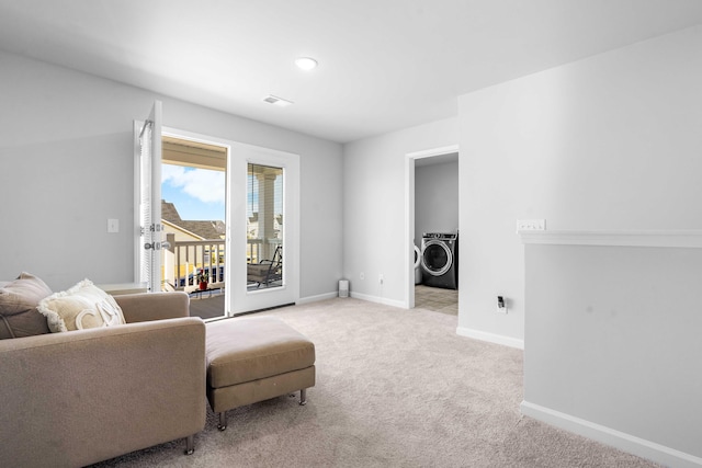 sitting room with light carpet, visible vents, washer / dryer, and baseboards