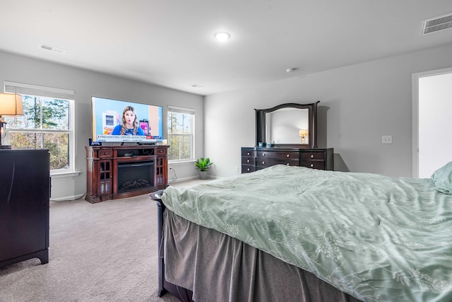 bedroom with a fireplace, visible vents, carpet floors, and baseboards