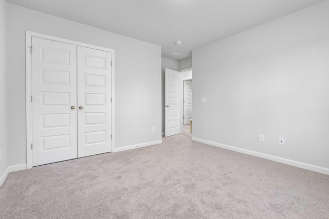 unfurnished bedroom featuring carpet, a closet, and baseboards