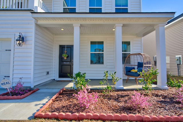 doorway to property with a porch and a garage