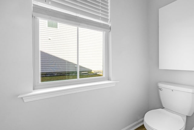 bathroom featuring baseboards and toilet