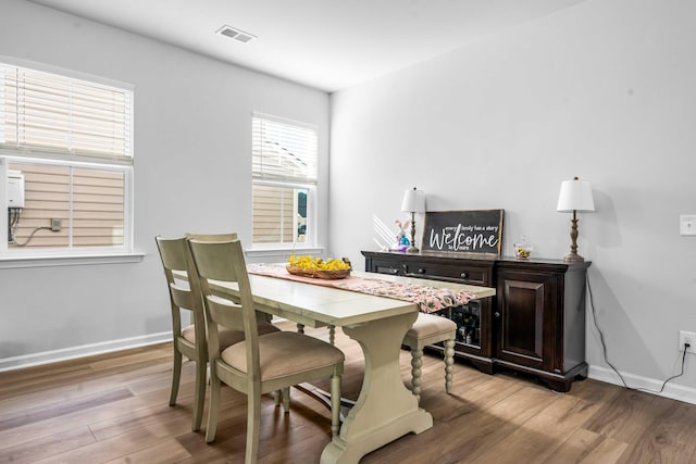 dining room with visible vents, light wood-style floors, and baseboards