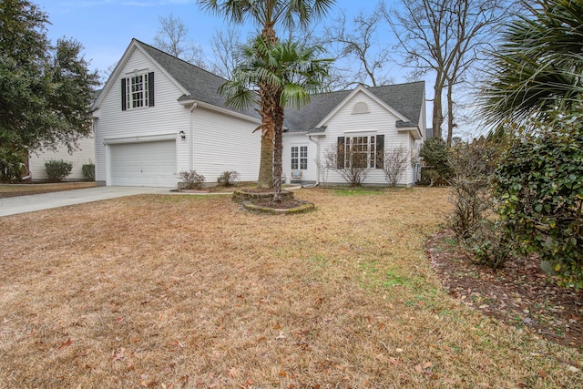 traditional-style house with an attached garage, driveway, a front lawn, and a shingled roof