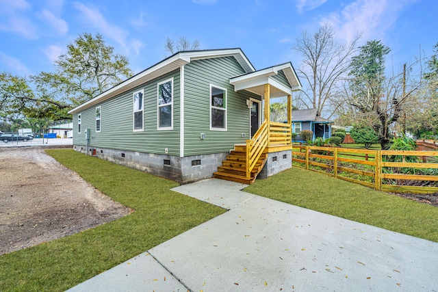 view of front of home featuring crawl space, driveway, a front lawn, and fence