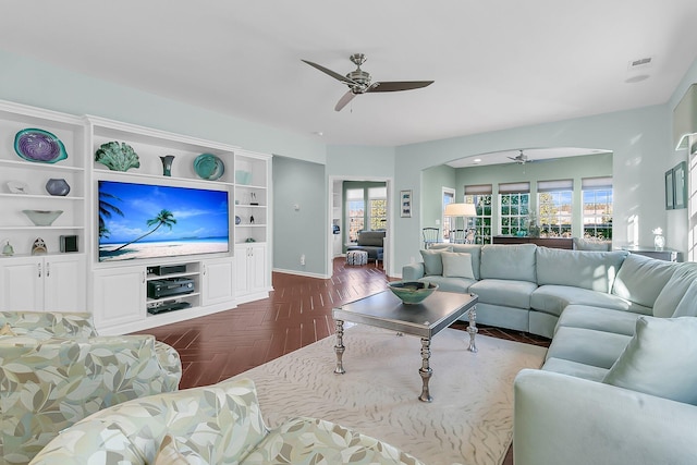 living room featuring dark parquet flooring, a wealth of natural light, and ceiling fan