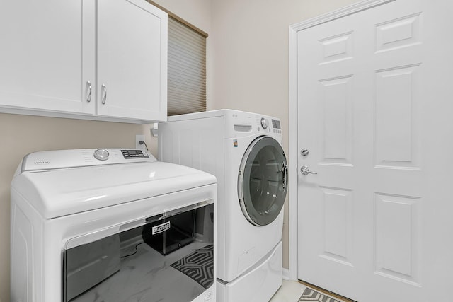 laundry area featuring separate washer and dryer and cabinets