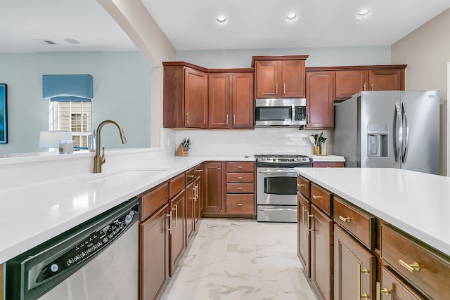 kitchen with tasteful backsplash, appliances with stainless steel finishes, and sink