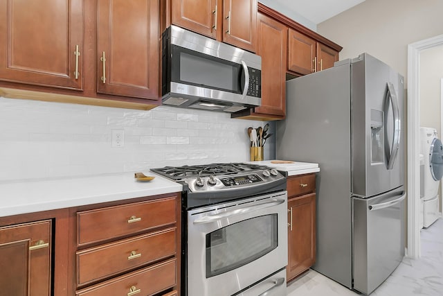 kitchen featuring decorative backsplash, washer and clothes dryer, and appliances with stainless steel finishes