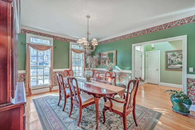 dining space featuring crown molding, light hardwood / wood-style flooring, and an inviting chandelier