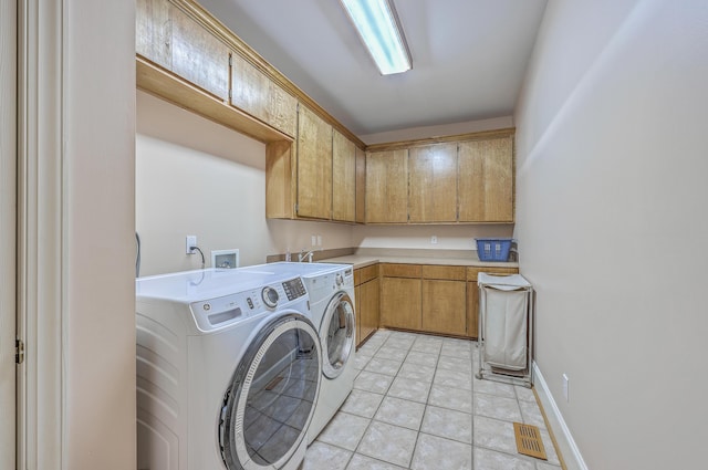 washroom with cabinets, separate washer and dryer, and light tile patterned floors