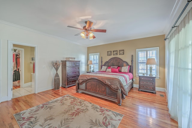 bedroom featuring ensuite bath, light hardwood / wood-style flooring, ceiling fan, and crown molding