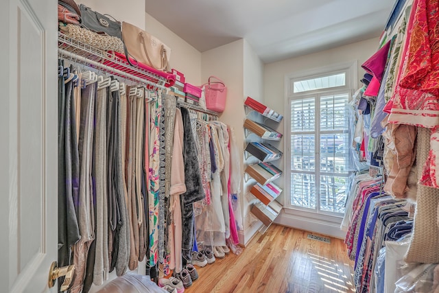 walk in closet with light hardwood / wood-style flooring