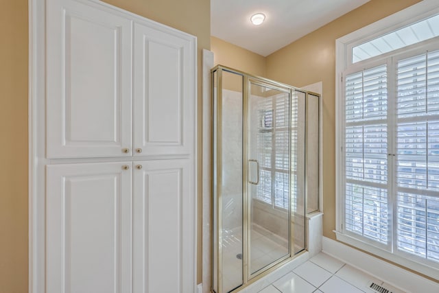 bathroom with tile patterned flooring and walk in shower