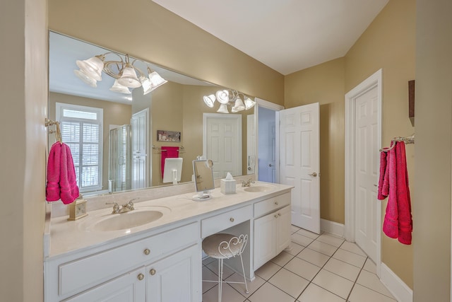 bathroom with tile patterned flooring, vanity, and an inviting chandelier