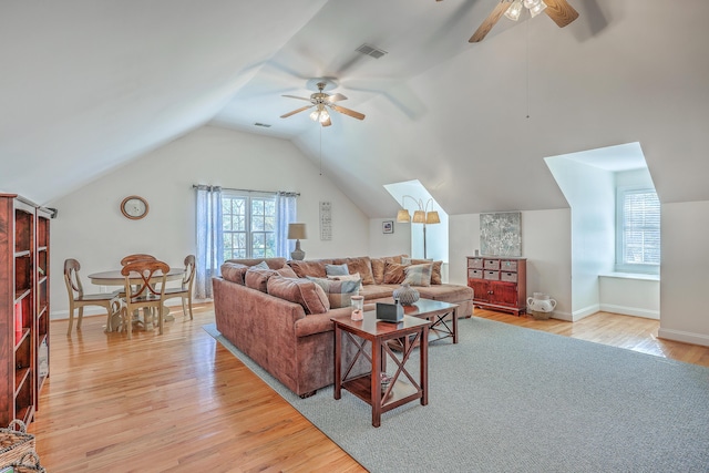 living room with ceiling fan, light hardwood / wood-style flooring, and lofted ceiling