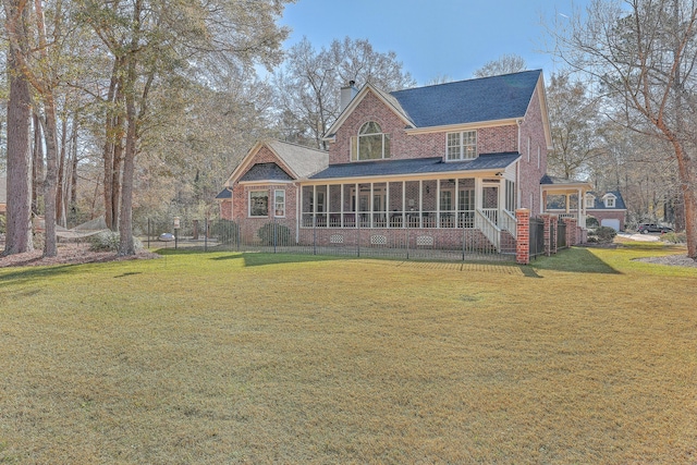 rear view of house featuring a sunroom and a yard