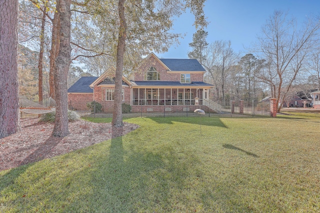 rear view of property featuring a lawn and a sunroom