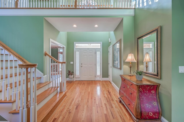 entryway with hardwood / wood-style floors and a high ceiling