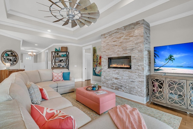 living room featuring ornamental molding, wood-type flooring, and a tray ceiling