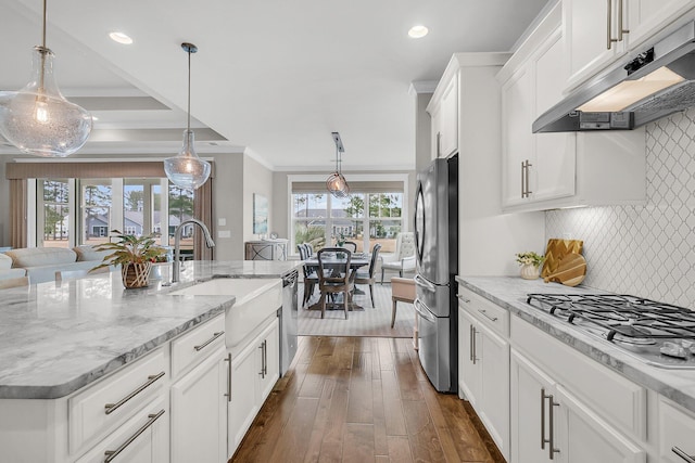 kitchen featuring sink, white cabinetry, hanging light fixtures, a center island with sink, and stainless steel appliances