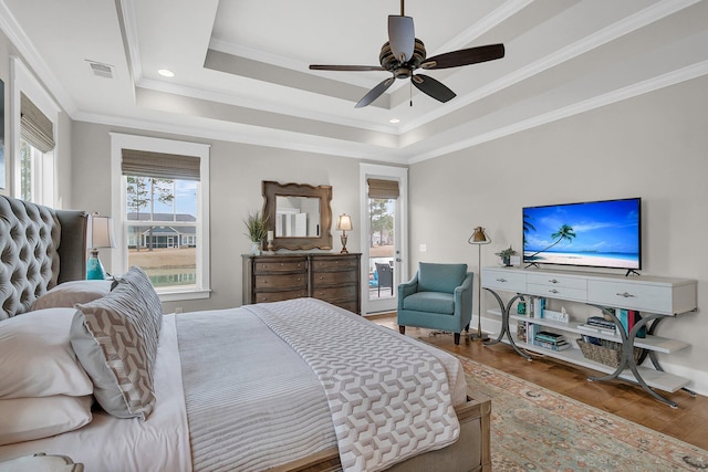 bedroom with access to exterior, ceiling fan, a raised ceiling, crown molding, and light hardwood / wood-style flooring