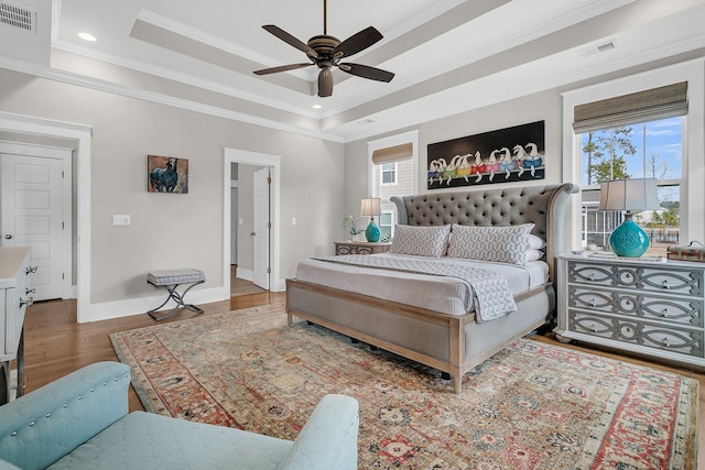 bedroom featuring ornamental molding, a tray ceiling, and dark hardwood / wood-style flooring