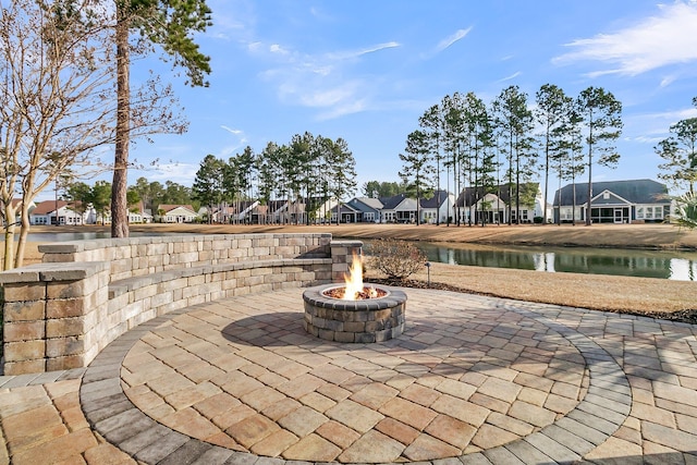 view of patio with a water view and an outdoor fire pit