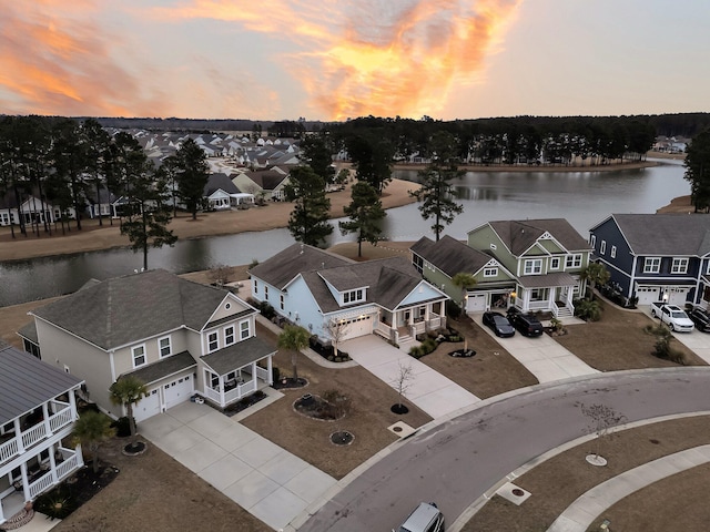 aerial view at dusk featuring a water view