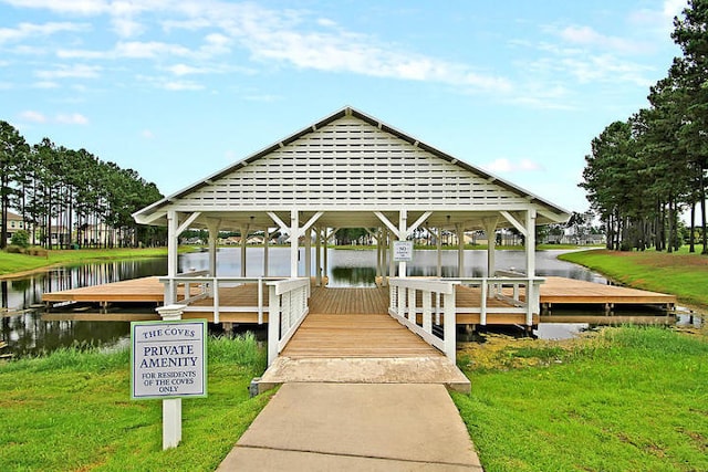 view of dock with a gazebo, a water view, and a lawn