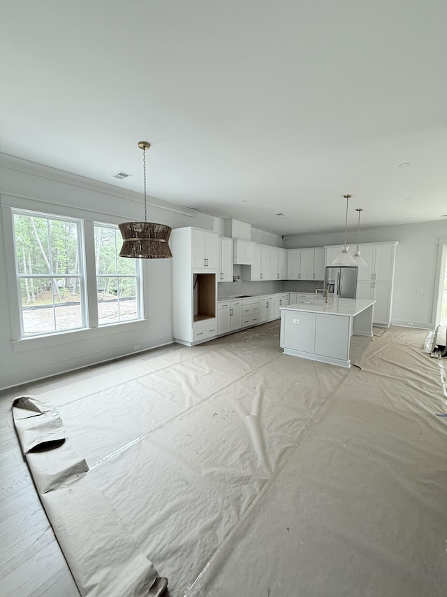 2790 Burden Creek Rd, Johns Island, SC 29455 - kitchen featuring stainless steel fridge with ice dispenser, white cabinetry, a chandelier, and pendant lighting