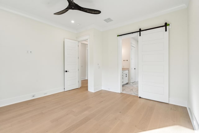 2790 Burden Creek Rd, Johns Island, SC 29455 - unfurnished bedroom with a barn door, light wood-type flooring, baseboards, ensuite bath, and recessed lighting
