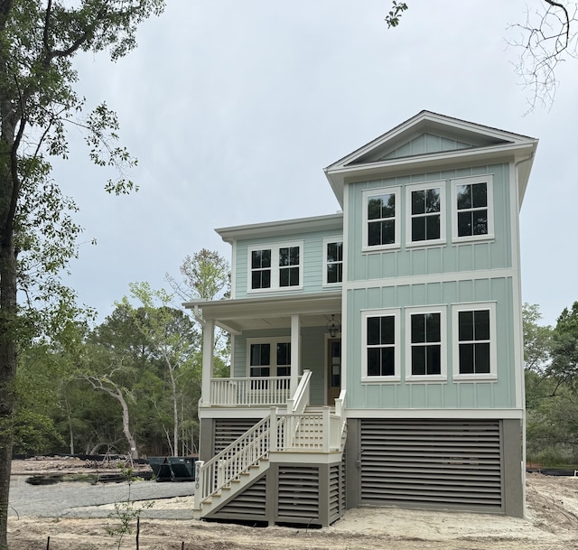 2790 Burden Creek Rd, Johns Island, SC 29455 - coastal inspired home with stairs, covered porch, and board and batten siding