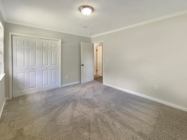 unfurnished bedroom featuring crown molding, a closet, and carpet