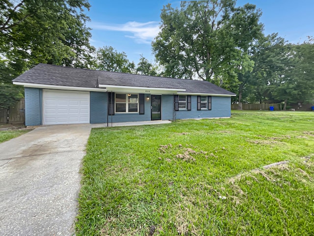 single story home with covered porch, a garage, and a front yard