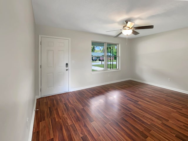 spare room with a textured ceiling, ceiling fan, and dark wood-type flooring