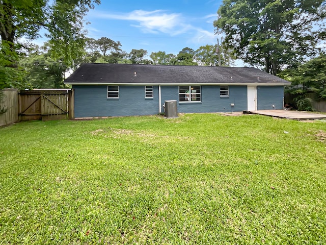 back of property featuring a yard and central AC