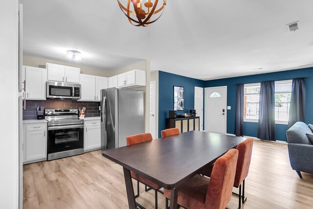 334 Water Oak Dr, Goose Creek, SC 29445 - kitchen featuring stainless steel appliances, light wood finished floors, white cabinets, tasteful backsplash, and a chandelier