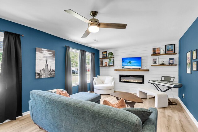 334 Water Oak Dr, Goose Creek, SC 29445 - living room featuring light wood-style floors, a glass covered fireplace, baseboards, an accent wall, and ceiling fan