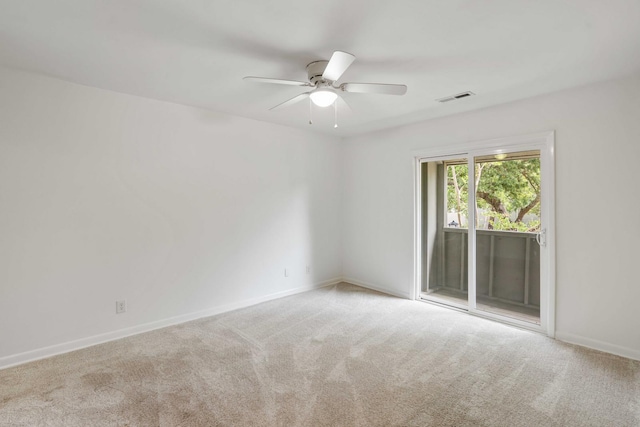 carpeted spare room featuring a ceiling fan and baseboards