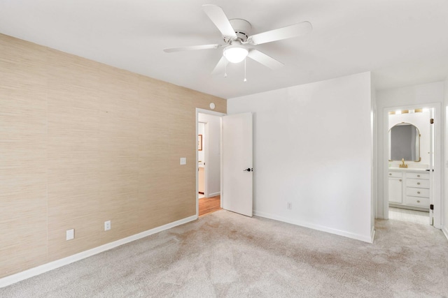 unfurnished bedroom with carpet, baseboards, ensuite bath, and a ceiling fan