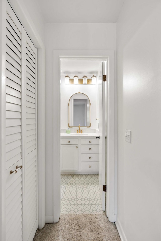 corridor with a sink and light floors
