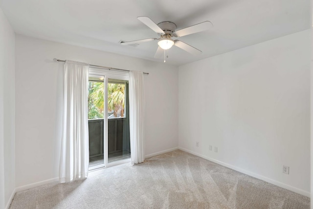 carpeted spare room featuring a ceiling fan and baseboards