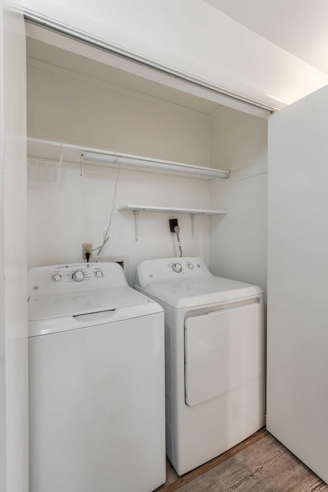 laundry area featuring washer and dryer and light wood-type flooring