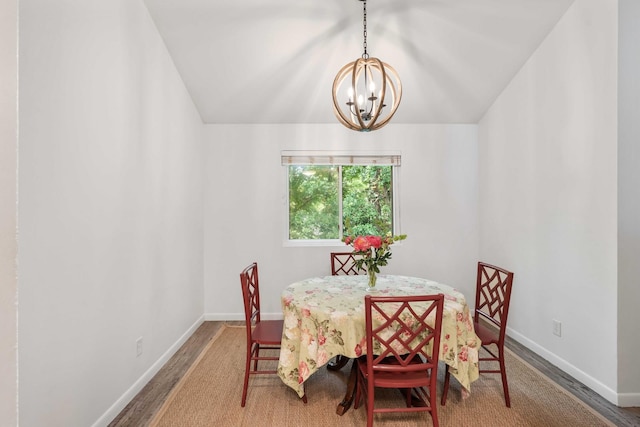 dining room featuring a chandelier, wood finished floors, and baseboards