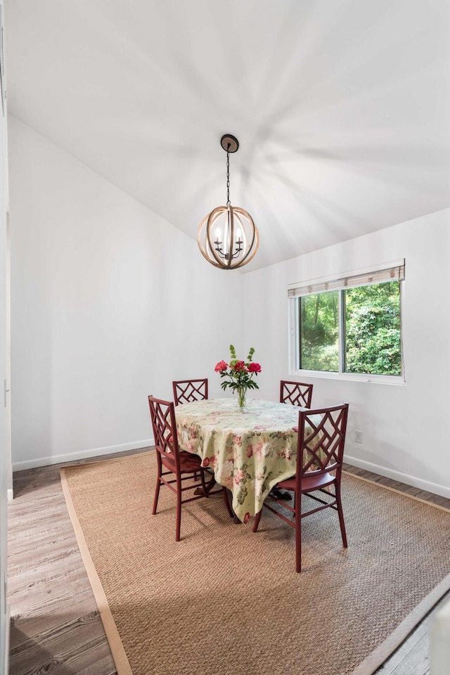 dining area with a chandelier, wood finished floors, and baseboards